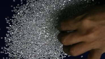 An employee sifts diamonds at a diamond factory in Surat.