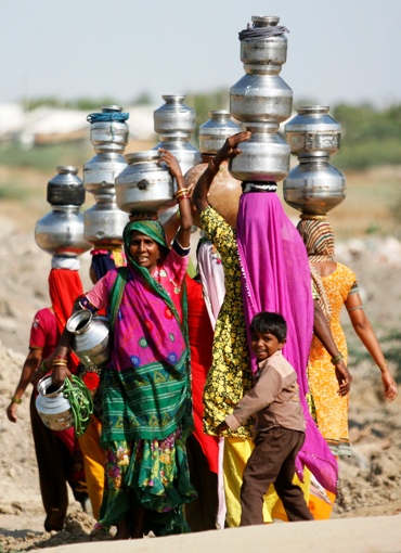 Villagers carry pitchers filled with water after visiting a well at Meni village in Gujarat.