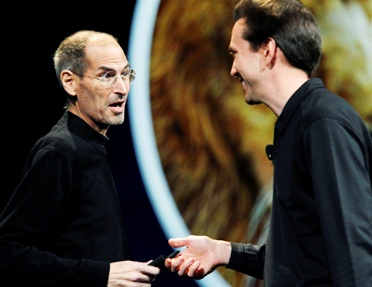 Steve Jobs takes the stage from Scott Forstall at an Apple event.