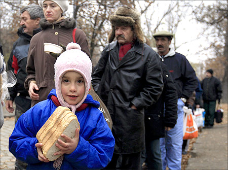 A girl receives bread from Krishna followers in Budapest.