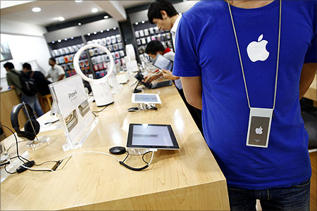 An employee stands inside a fake Apple Store in Kunming,