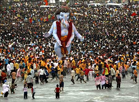 Devotees carry a statue of the Hindu elephant god Ganesh, the deity of prosperity.