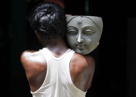 An artisan carries a sculpture of Goddess Durga in Kolkata.