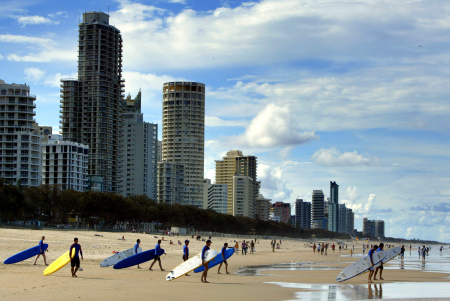 Longboard surfers walk into the water at Surfer's Paradise, 60 kilometres southeast of Brisbane.