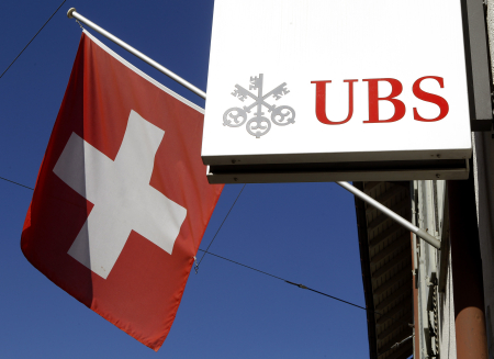 Switzerland's national flag is seen beside the logo of Swiss bank UBS in the town of Riehen.