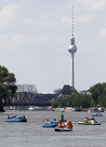 People use paddleboats on the river Spree during a sunny day in Berlin.