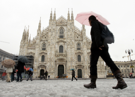 People walk past Duomo Cathedral after a snowfall in Milan.