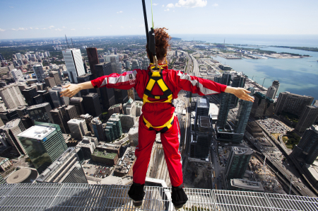 A reporter leans over the edge of the catwalk during the media preview for the 'EdgeWalk' on the CN Tower in Toronto.