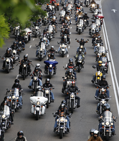 Motorcyclists ride down the central avenue in Madrid.
