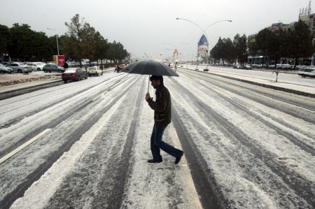 A man walks on a road after heavy rain and a hailstorm hit Islamabad.