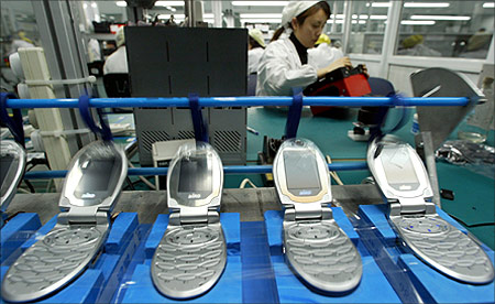 A Chinese worker tests mobile phones at Ningbo Bird Co. Ltd production line.