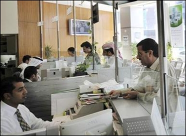 Bank tellers are seen interacting with customers at the Dubai Islamic Bank in Dubai.