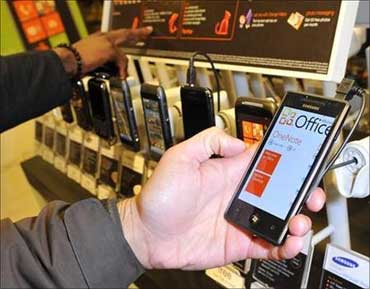 A customer views a mobile phone with the new Windows 7 operating system.