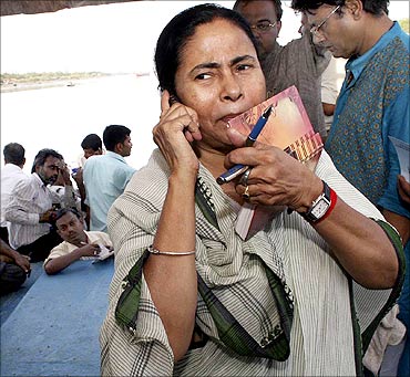 Mamata Banerjee speaks on a mobile phone during her visit to a cyclone-hit site in West Bengal.