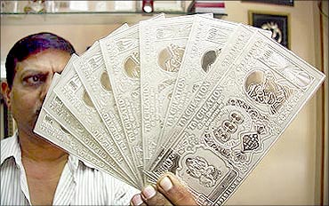 A jeweller displays silver plates in the form of Indian rupee notes in Chandigarh.