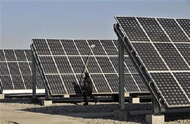A worker cleans solar panels