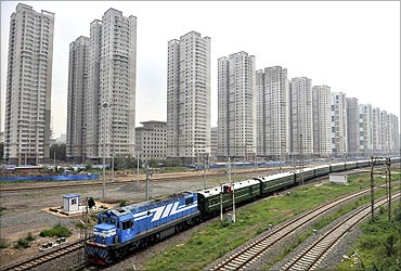 A train runs past newly-built residential buildings in Shenyang, Liaoning province.