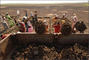 Labourers load a truck as they try to revive a dried lake under the NREGA at Ibrahimpatnam, Hyderabad.