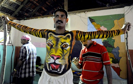 A dancer has his body painted to look like a tiger before he performs during Onam festival in Trichur, Kerala.