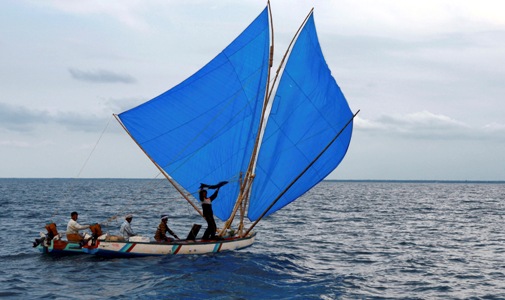 An Indian fisherman shows a fish to the participants of the Volvo Ocean Race in Kochi.
