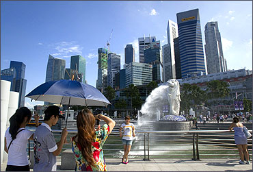 Merlion, the mascot of Singapore, and the financial district skyline.