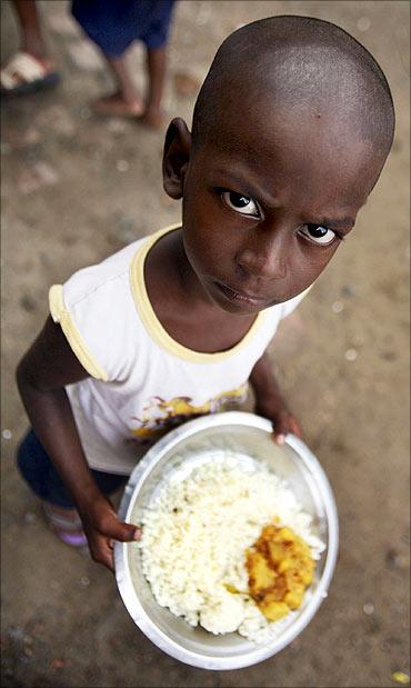 A student holds his free mid-day meal, distributed by a government-run primary school, in Rajpore