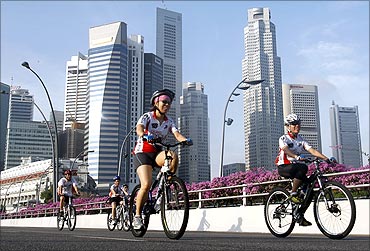 Participants cycle past the financial district skyline during the OCBC Cycle Singapore event.