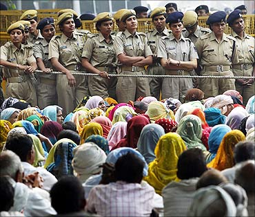 Police stand guard as farmers listen to a speaker during a protest in New Delhi.