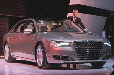 A staff member stands next to a new Audi A8 L W12 Quattro car during its world premiere ceremony at the Beijing Auto Show in Beijing April 23, 2010.