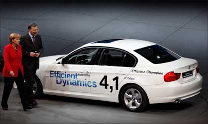 German Chancellor Angela Merkel and BMW CEO Norbert Reithofer pass a BMW Efficient Dynamics 320d.
