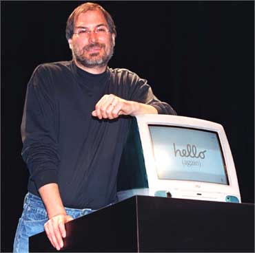 Jobs stands by iMac computer as he addresses the Apple Expo in Paris on Sept 17, 1998.