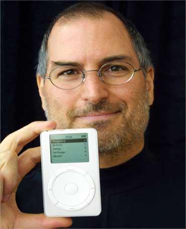 Jobs holds up the MP3 music player at an exibition on October 23, 2001.