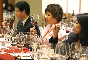 Wine lovers try red wine during a Chateau Haut Brion wine-tasting event in Beijing.