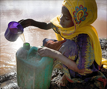 A child collects water from a pond used by animals