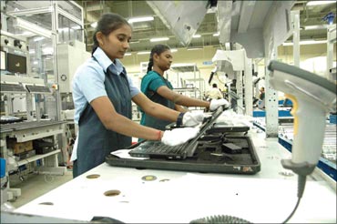 Two girls work at the Dell laptop assembly line in Sriperumbudur.