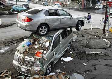 A car sits atop another in an area affected by an earthquake and tsunami in Miyako.