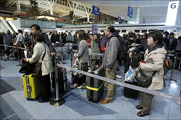 Passengers line up to get their plane tickets at Haneda Airport in Tokyo.