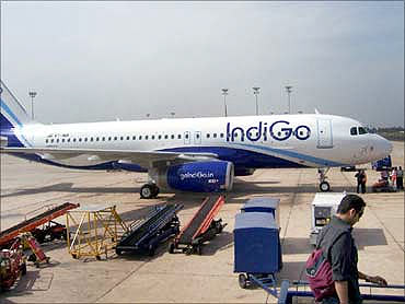 An IndiGo aircraft at an airport parking bay.