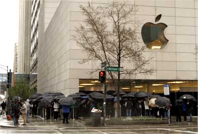 Hundreds of people stand in line in a steady rain to purchase the iPad.