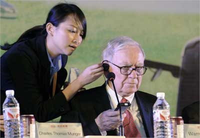 Buffett tests a translation device during a news conference at a BYD plant in Changsha, Hunan.