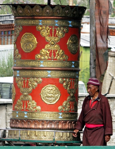 A Buddhist monk spins a 'Manay' or prayer wheel in Leh.
