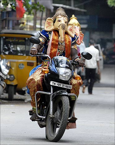 A man dressed as a Hindu god Ganesh, the deity of prosperity, rides a motorcycle in Chennai.