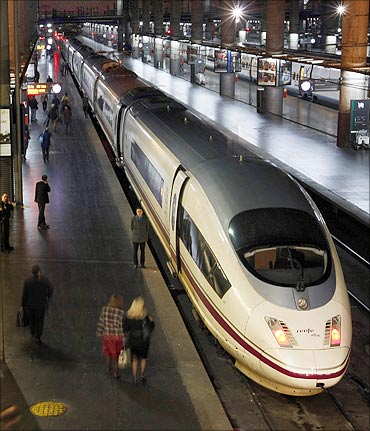 Passengers board the first AVE train linking Madrid to Barcelona at Madrid's Atocha station.