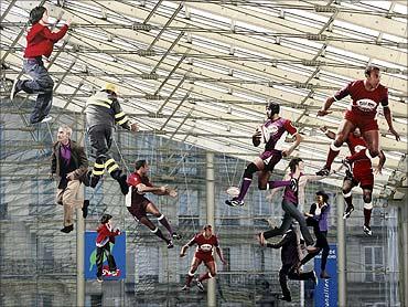 Models of rugby players and citizens hang in the Gare du Nord railway station in Paris.