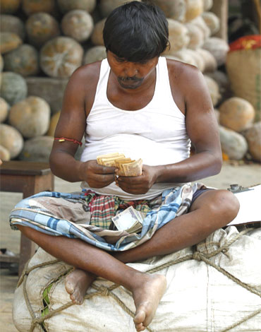A trader counts money at a wholesale vegetable market in Kolkata.