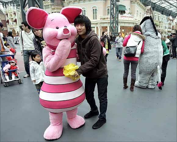 A Thai tourist poses with Disney character Piglet at Tokyo Disneyland in Urayasu, north of Tokyo.