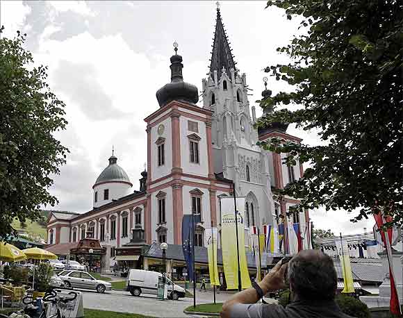 A tourist takes a picture of the basilica of the Styrian town of Mariazell.