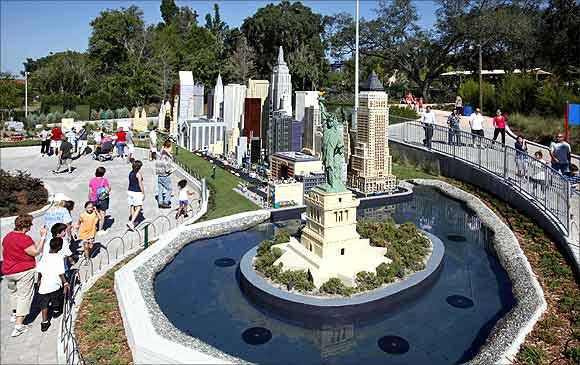 Visitors walk past the Statue of Liberty and part of the New York skyline, constructed out of lego bricks.