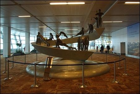 Sculpture at T3 terminal depicting twelve asana's of the Surya Namaskar.