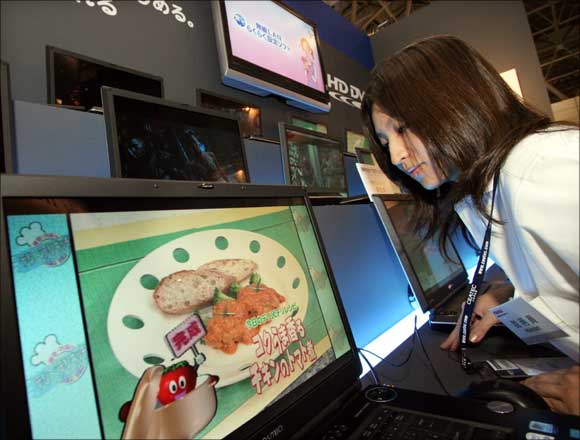 An attendant shows Toshiba's new HD DVD notebook PCs at the Combined Exhibition of Advanced Technologies.